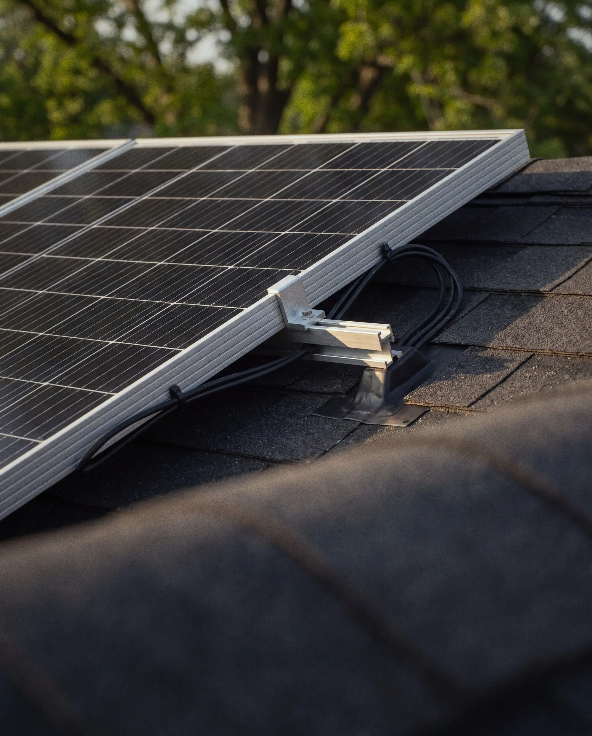 Close detail of a well-kept rooftop solar panel frame, mounting clamp and wiring
